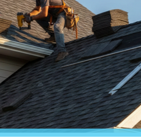 A professional roofer installing dark gray asphalt shingles on a residential home with a clear blue sky background, showing the layered installation process without any text overlay